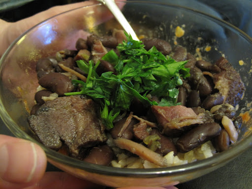 Red beans and rice garnished with chopped flat parsley and green onions.