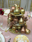 Plastic fruit that we tied into our pink and gold color palette serves as a stylish and inexpensive centerpiece. Plastic fruit that we tied into our pink and gold color palette serves as a stylish and inexpensive centerpiece.