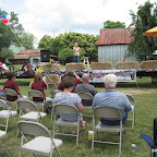 Audience Gathers - Some Sit In Chairs and .....