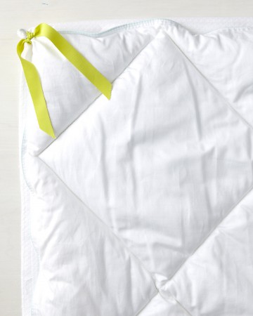 Keep your duvet and your comforter in place by turning the cover inside out and sewing two pieces of five-inch-long fabric tape to all four corners. Then tie the fabric tape around each corner of the comforter. Keep your duvet and your comforter in place by turning the cover inside out and sewing two pieces of five-inch-long fabric tape to all four corners. Then tie the fabric tape around each corner of the comforter.