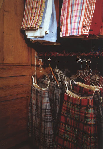 The Duke of Windsor's closet at the Mill, France, with tartan pants and kilts perfectly pressed and lined up in regimental order.