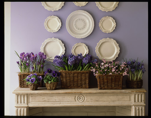 Spring bulbs tucked inside baskets on this mantle arrangement create a beautiful spring landscape.