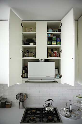 The cabinet above the cook top houses a fan and vent that creates small cubbies perfect for storing cooking oils, spices, wraps, storage bags and other small kitchen tools. The cabinet above the cook top houses a fan and vent that creates small cubbies perfect for storing cooking oils, spices, wraps, storage bags and other small kitchen tools.