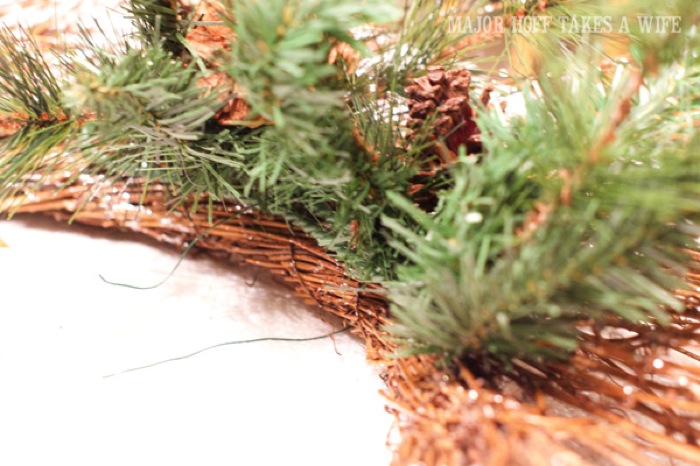 Use floral wire to secure greenery to wreath. World Market inspired wreath. A fun twist on a Christmas wreath. Make a winter wreath that will last all season long and well past. This cute grapevine wreath is adorned with a tiny bird, pinecones, greenery and pom poms. You won't believe how cheap and easy this was to make! And so simple! #Christmas #winter #holiday #wreath #nature #knockoff Use floral wire to secure greenery to wreath. World Market inspired wreath. A fun twist on a Christmas wreath. Make a winter wreath that will last all season long and well past. This cute grapevine wreath is adorned with a tiny bird, pinecones, greenery and pom poms. You won't believe how cheap and easy this was to make! And so simple! #Christmas #winter #holiday #wreath #nature #knockoff