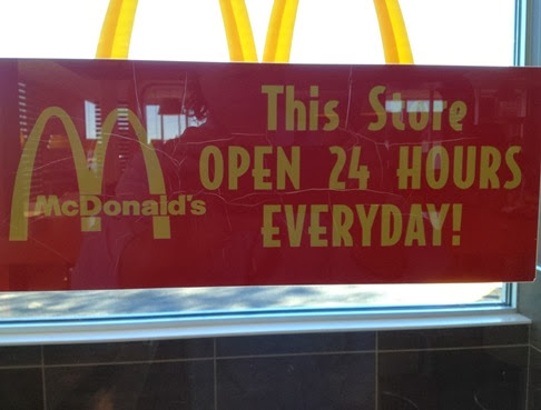 c0 This McDonalds door sign signs says 'This Store OPEN 24 HOURS EVERYDAY'