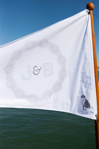 Jesse designed the flag, which featured the couple's initials surrounded by a wave-like pattern to mimic the water. The couple's pup, Bleu, made an appearance on the corner, and was the bride's Jesse designed the flag, which featured the couple's initials surrounded by a wave-like pattern to mimic the water. The couple's pup, Bleu, made an appearance on the corner, and was the bride's
