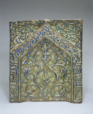 Panel from a mihrab | Origin:  Probably Kashan,  Iran | Period: early 14th century  Il-Khanid period | Details:  This glazed panel, adorned with an arabesque design in relief, originally formed the upper section of large tile mihrab . It is inscribed with a verse from the Koran (sura 11, verse 114): In the name of God, the Merciful, the Compassionate.  Perform prayer morning and evening, and in the watches  of the night. Behold, good works and drive away evil. | Type: Molded stone-paste; painted under glaze with color and over glaze with luster | Size: H: 66.4  W: 59.0   D: 10.7  cm | Museum Code: F1909.319 | Photograph and description taken from Freer and the Sackler (Smithsonian) Museums.