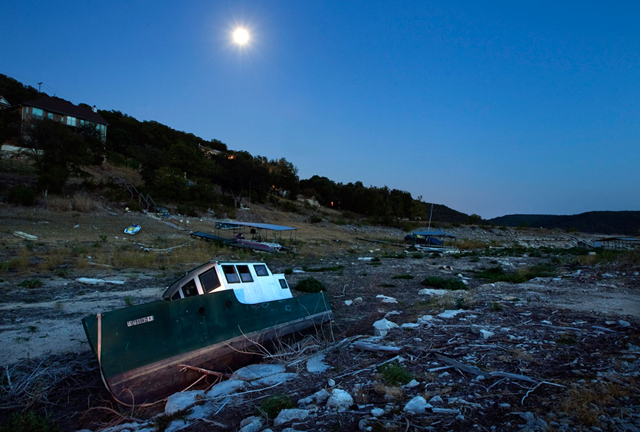 On a moonlit night on Wednesday, August 10, 2011, a boat is beached in the Cypress Creek arm of Lake Travis. Waterfront properties in this area of Lake Travis barely have a view of water, and their boats and docks rest on dry land. statesman.com