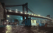 Streets are flooded under the Manhattan Bridge in the Dumbo section of Brooklyn, N.Y., Monday, Oct. 29, 2012. Sandy continued on its path Monday, as the storm forced the shutdown of mass transit, schools and financial markets, sending coastal residents fleeing, and threatening a dangerous mix of high winds and soaking rain. (AP Photo/Bebeto Matthews)