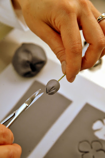 Then, she uses a small scissor to snip the center.