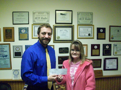 Winner of the Christmas Cash Call Felicia Humphries receives her check for $1,000 from KCII General Manager Joe Nichols