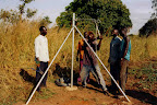 Workmen straining supporting wires ready for attaching chain-link fence on CFA land