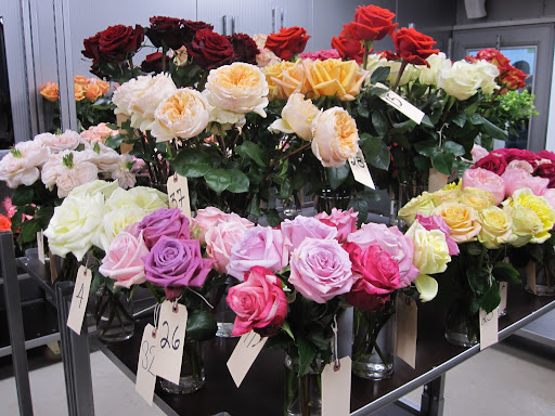 On a table at he back of the shop is a display of roses that are not available yet at the store.