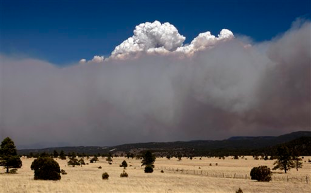 A smoke plume over the east side of the Wallow Fire climbs high into the sky Monday afternoon, June 6, 2011, as strong winds fanned the Wallow Fire in Eager, Ariz. AP Photo / The Arizona Republic, Pat Shannahan
