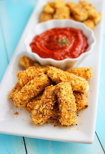 Skinny Baked Mozzarella Sticks – Everyone's favorite indulgence made skinny! Ooey gooey mozzarella sticks hot out of the oven = snacking heaven! | thecomfortofcooking.com