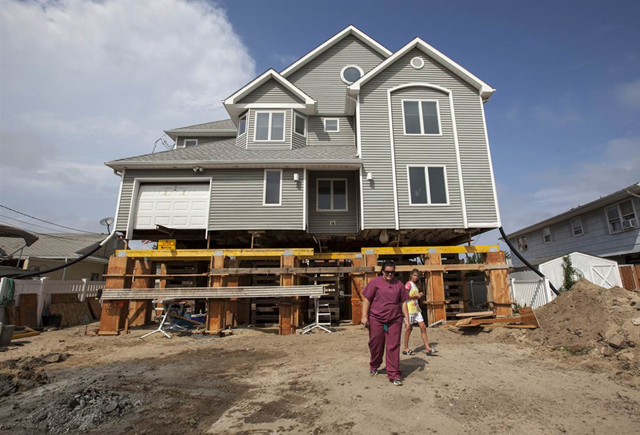 Marlo Lutz, 44, and her daughter Harlie, 12, leave their home in Toms River, N.J., after checking the progress of ongoing construction. Earlier that day, a crew poured new concrete piers to lift the structure 13 feet above sea level. Newly-redrawn FEMA maps of the region&rsquo;s flood zones placed the Lutz&rsquo;s home in a high-risk category, requiring them to lift the property to mitigate future flood damage. Photo: John Makely / NBC News