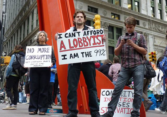 Protester sign: 'I can't afford a lobbyist. I am the 99%'. 'Occupy Wall Street' protesters march and hold signs in New York City on September 17, 2011. Frustrated protesters have been speaking out against corporate greed and social inequality on and near Wall Street for weeks. Carwil Bjork-James / flickr