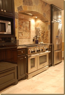 Black cabinets Stone arch Stainless range