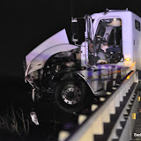 A propane truck slams into an abandon vehicle parked in the number three lane on the bridge. The propane truck ends up across all lanes with the front end of the truck crashed through the guard rail and hanging over the edge. Diesel fuel was leaking from the fuel tanks however the trucks payload was empty. The guardrail crashed below landing on powerlines and causing a fire on the roadside below. No one was injured and reason for the car being parked and left on the highway bridnge is unknown. The vehicle was not stolen per CHP. News_110305_PropaneTruckIncident
