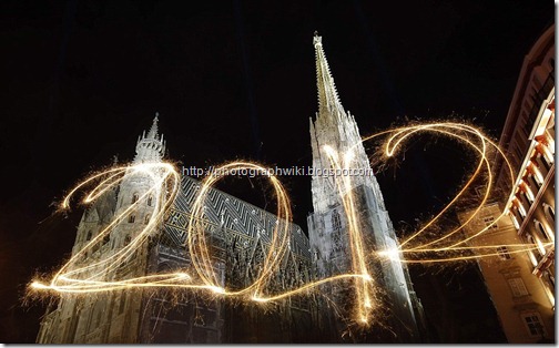 The number 2012 is written with sparklers during a long exposure in front of St Stephen's Cathedral during New Year's Eve celebrations