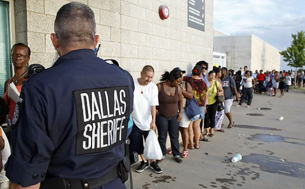 A Dallas County sheriff's deputy monitors the line for rental assistance voucher applications on the morning of 14 July 2011 outside the Jesse Owens Memorial Complex in Dallas. Thousands of people turned out to apply as Dallas County's housing agency started accepting applications for the first time in five years. David Woo / Staff Photographer
