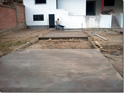 miembros de la comunidad apoyan en la construcción de la losa deportiva