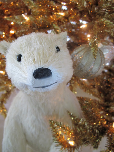 A polar bear peaking through the Christmas Trees.