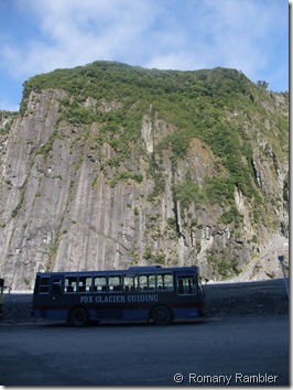 Bus under cliff at Fox Glacier