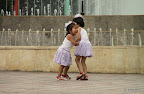 Two Kyrgyz girls dancing in front of a fountain