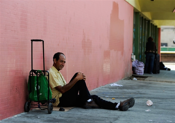 Juan Morena sits on a Los Angeles, Calif., sidewalk as he waits for the St. Francis Center soup kitchen to open on 13 Sept 2011. Kevork Djansezian / Getty Images, file