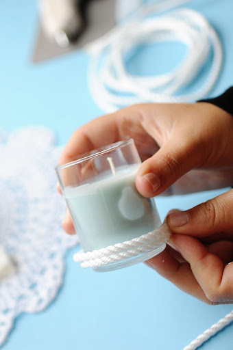 Step 9: Place a dot of hot glue at the bottom outside of the candleholder, and attach one end of the boat rope to it. Let it dry for 15 seconds. Step 9: Place a dot of hot glue at the bottom outside of the candleholder, and attach one end of the boat rope to it. Let it dry for 15 seconds.