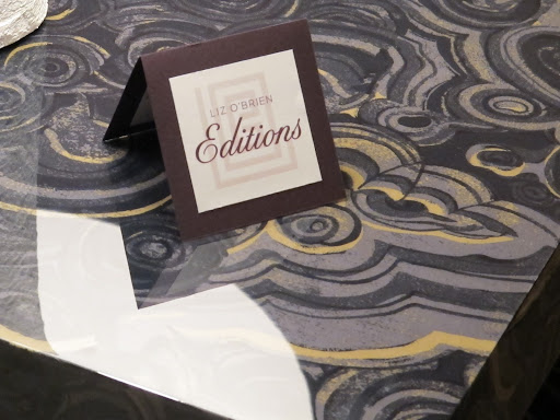 Welcome to the opening! The design on this table is actually real fabric sealed under a glossy coating.