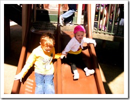 Christian and Vivian down the slide holding hands Christian and Vivian down the slide holding hands