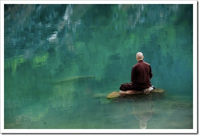 monk-meditating-on-rock-in-lake