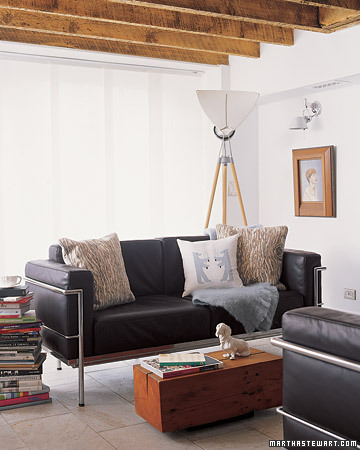 A black leather couch offsets the airy white walls of this cozy living room.
