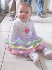 Cassie first birthday party sitting on floor