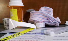 c0 a picures of a newborn's bonnet, hospital wrist bands, a prescription bottle, and a new social security card.