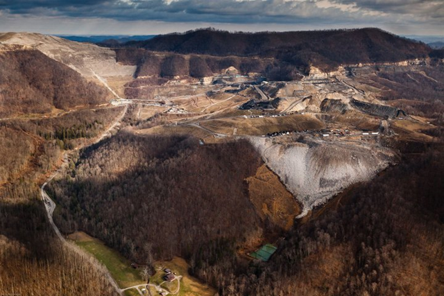 A Mountaintop Removal mine site and its accompanying valley fill hovers over a resident's home in Fayette County, WV. This site is operated by Frasure Creek Mining LLC which was sued in 2010 by four environmental groups for violations regarding their MTR in Kentucky. They were accused of committing over 20,000 water discharge violations and fraud for falsifying reports. Photo: Paul Corbit Brown
