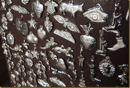 Milagro charms adorn the stand for the mission bell housed inside the church
