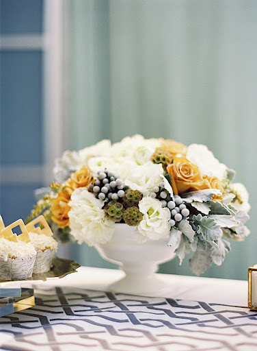 Arrangements of cream-colored flowers (hydrangea, ranunculus, pieris) dotted with gray dusty miller foliage, silver brunia, and muted peach garden roses were used. Arrangements of cream-colored flowers (hydrangea, ranunculus, pieris) dotted with gray dusty miller foliage, silver brunia, and muted peach garden roses were used.