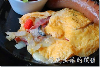 台南-PS-Cafe-Brunch。歐姆捲蛋內有切丁的洋蔥、去子的蕃茄、培根肉、黑橄欖，還有會拉絲的起司，個人推薦這道菜色。如果蛋皮可以再煎得軟嫩一點會更棒。