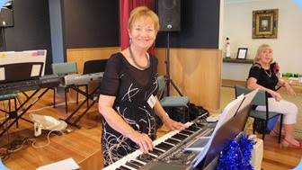 Events Manager, Diane Lyons, playing her Korg Pa900 whilst Margaret Black watches on whilst crewing the Entry Desk. Photo courtesy of Dennis Lyons.