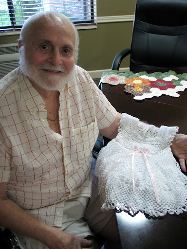 Dick Du Puis with the Christening dress made for the daughter of Christian Health Care employee. (Photo credit: Jennifer Moore)