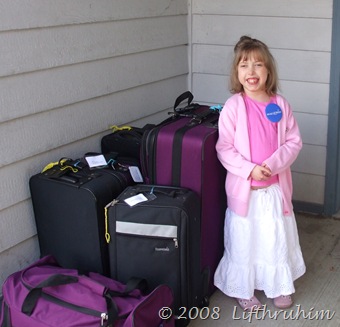 Supergirl with the luggage waiting for the shuttle.