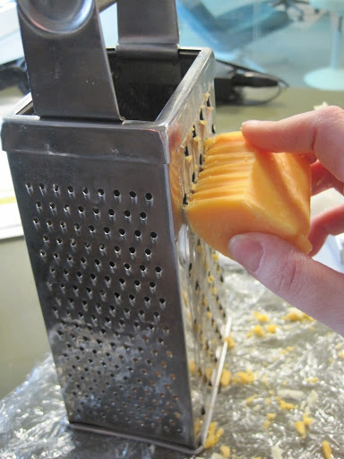 Using the widest holes of a box grater, Monty grates some extra-sharp cheddar. Using the widest holes of a box grater, Monty grates some extra-sharp cheddar.