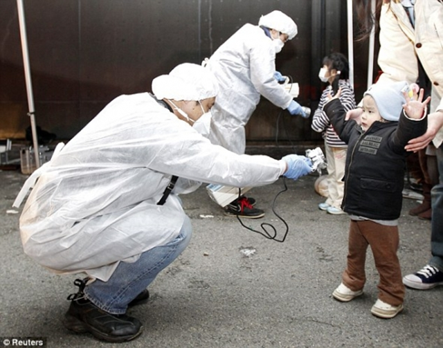 Officials carry out radiation tests on children who were evacuated from the area near Fukushima, 13 March 2011. Reuters / dailymail.co.uk