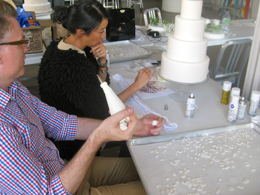 Michael and Katie collaborating on the design of the candy necklace that drapes around the cake.