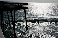 Surfers under the pier at Pismo Beach