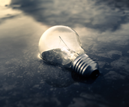 c0 A picture of a light bulb burning dimly and partially submerged under water