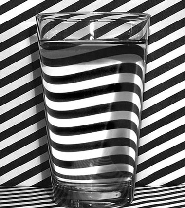 glass-of-water-on-black-and-white-striped-background-445x500